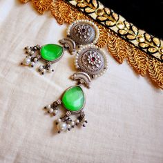 These Ethnic Indian Earrings Are Made Of High-Quality Metal And Are Perfect For Adding A Touch Of Elegance To Any Outfit. The Earrings Feature A Beautiful Green Drop Design That Is Sure To Catch The Eye, And They Are Lightweight And Comfortable To Wear. Whether You're Attending A Wedding Or A Party, These Earrings Are A Great Way To Dress Up Your Look. Bohemian Drop Earrings For Festive Season, Handmade Green Bohemian Jhumkas, Festive Bohemian Drop Earrings, Festive Green Bohemian Earrings, Traditional Green Metal Earrings, Green Bohemian Dangle Jhumkas, Unique Green Earrings With Oxidized Finish, Green Earrings With Oxidized Finish, Green Bohemian Chandbali Danglers