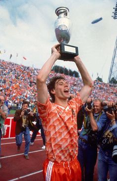 a man holding up a trophy in front of a crowd