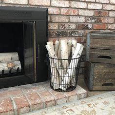 a basket full of firewood next to a fireplace