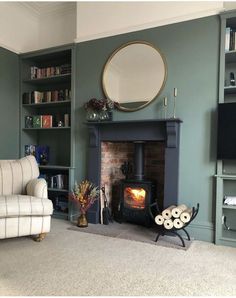 a living room filled with furniture and a fire place next to a book shelf full of books