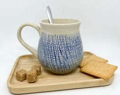 a blue and white mug with crackers on a tray