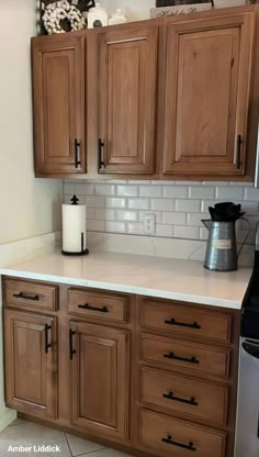 a kitchen with wooden cabinets and white counter tops