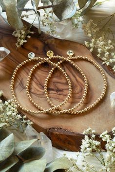 Our Golden Beaded Bracelet is a simple yet radiant addition to any fit representing strength, abundance, and happiness. High-quality 14k Goldfilled beads will last, won't tarnish, and will shine all night long. Choose between one bracelet or layer with our set of two, or stack of three. Golden Beaded Bracelet is handcrafted with 3mm smooth 14k Goldfilled beads on a strong elastic cord. Signature MB gold charm. Each piece is handmade delicately with love and care. All Bracelets are unique and special, variation in color and inclusions in the gemstones are natural. Please take off when swimming, showering, and during hot yoga as water can damage thread. Bathe in moonlight regularly to renew crystals. Enjoy!Light & Love! Bracelet Size Chart, Mala Bracelet, Tree Free, Hot Yoga, Gold Charm, Bracelet Sizes, Bracelet Set, Beaded Bracelet, Gold Bracelet