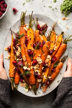 roasted carrots with cranberry sauce and almonds on a white platter