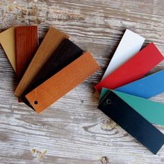 four different colors of wood are on the table together, and one is black, white, red, blue, green, yellow