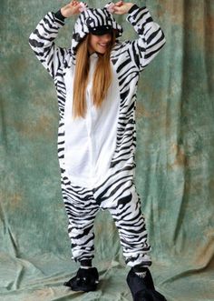 a woman in a zebra onesuit posing for a photo with her hands on her head