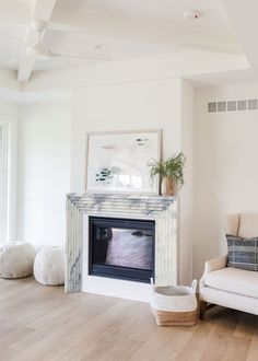 a living room with a couch, chair and fire place in the middle of it