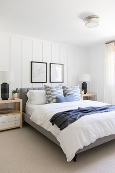 a bed with white sheets and blue pillows