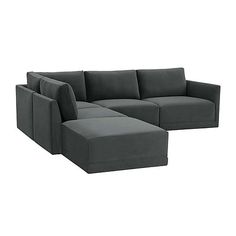 a large gray couch sitting on top of a white floor next to a footstool