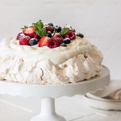 a white cake with berries and cream on top