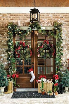 christmas wreaths are hanging on the front door