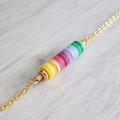 Colorful + Happy. Little tiny bits of clay in 17 different shades. Each piece carefully chosen then stacked one at a time and strung on wire with 14K gold plated beads at each end of the stack. Chain is a small link 14K gold plated chain with a matching lobster style clasp. Also available in bright polished silver plated metal {not shown}. { M e a s u r e m e n t s } Little pendant alone measures approx 1 inch {25mm}. Entire necklace when unclasped and measured from end to end is approx 19 inche Multicolor Adjustable Chain Jewelry For Friendship, Colorful Necklace With Adjustable Chain As Gift, Rainbow Color Necklace For Gift, Handmade Minimalist Rainbow Jewelry, Multicolor Personalized Dainty Jewelry, Dainty Multicolor Personalized Jewelry, Dainty Personalized Multicolor Jewelry, Rainbow Colorful Beads Jewelry For Friendship, Handmade Rainbow Jewelry For Friendship