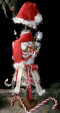 a christmas decoration with santa clause hat and candy canes on the top of it