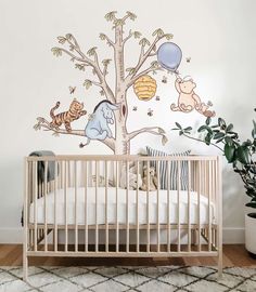 a baby's room with a crib and wall decals