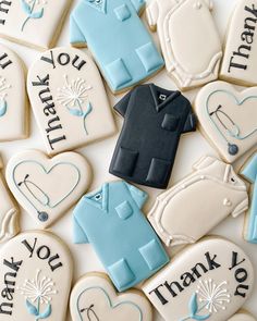 decorated cookies are arranged in the shape of golf shirts and sweaters with thank you written on them