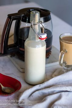 a pitcher of milk next to a cup of coffee