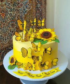 there is a yellow cake with butterflies on it