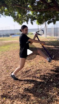 a woman holding a tennis racquet on top of a field