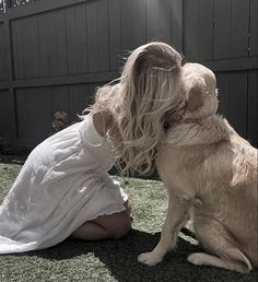 a woman kneeling down next to a dog