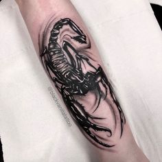 a man's arm with a black and white tattoo design on the left forearm