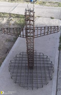 a large metal structure sitting on the side of a road