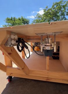 a machine is attached to the back of a wooden structure with wires and tools in it