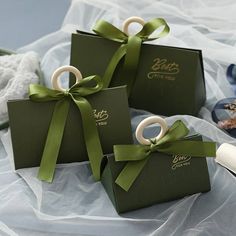 four green gift bags with ribbons tied around them