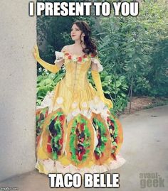 a woman in a yellow dress standing next to a wall with the words tacobelle on it