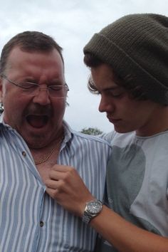 an older man and young boy standing next to each other with their mouths wide open