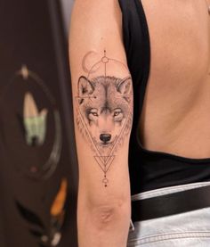 a woman with a wolf tattoo on her arm