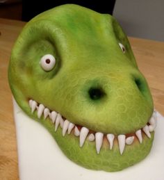 a close up of a cake decorated to look like a dinosaur's head with teeth