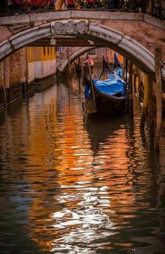 a gondola in the water under a bridge