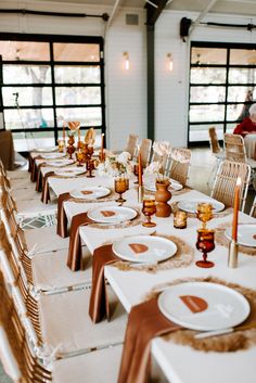 the tables are set with white plates and brown napkins