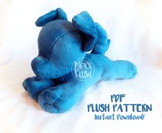 a blue stuffed animal laying on top of a white sheet with the words fox plush written below it