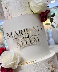 a wedding cake decorated with flowers and the words marriage and aleem on it's side