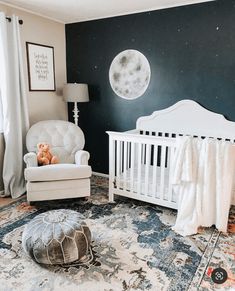 a baby's room with a white crib, rocking chair and large moon painted on the wall