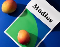 two peaches sitting on top of a table next to a sign that says madies