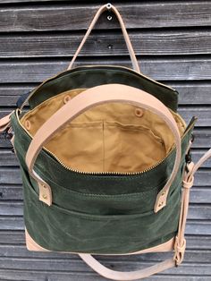 Tote bag with luggage handle attachment in American heavy weight waxed canvas. The color is olive green for the body and natural vegetable tanned leather for the bottom. I made it into an everyday bag perfect for the office, with leather handles, shoulder strap, and 3 outside pockets Closing with a zipper on top. And on the backside a luggage handle attachment Including a leather shoulder strap, adjustable and detachable. All made in natural vegetable tanned leather Fully lined with a cotton can Green Waxed Finish Tote Shoulder Bag, Green Waxed Canvas Bag For Daily Use, Green Duck Canvas Travel Bag, Green Waxed Canvas Tote Shoulder Bag, Green Waxed Canvas Bag For Everyday Use, Green Canvas Satchel With Leather Handles, Green Waxed Canvas Tote Bag, Green Waxed Canvas Everyday Bag, Everyday Green Waxed Canvas Bag