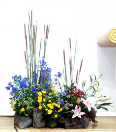 an arrangement of flowers is sitting on the floor