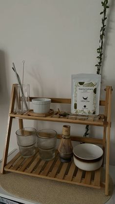 a wooden shelf with bowls and utensils on it