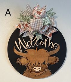 a welcome sign hanging on the side of a wall with a cow's head