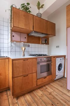 a kitchen with wooden cabinets and white tile backsplash, wood flooring and pink appliances