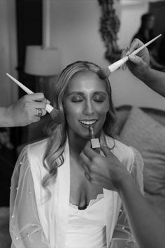 the woman is getting her makeup done by the hair stylist in black and white