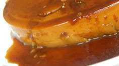 a piece of meat covered in gravy on top of a white plate with sauce