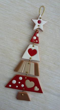 a christmas tree ornament with hearts and stars hanging from it's sides