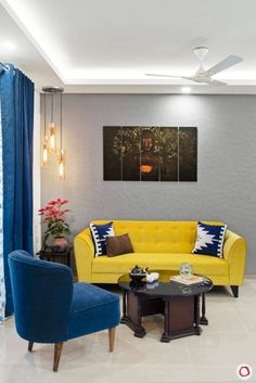 a living room with yellow couches and blue chairs