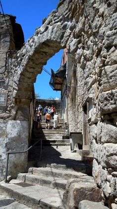 people are walking up and down the stairs in an old stone building that is being used as a tourist attraction