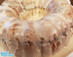 a bundt cake with icing sitting on top of a white plate next to a brown counter