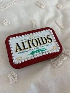 an altoids tin sitting on top of a bed