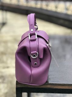 In the modern world, it is difficult to see a stylish lady without any accessory, where she could put everything necessary. For many years, bags made from natural materials have been very popular. This violet doctor style bag is created from genuine leather. Women's leather handbag always remains relevant, regardless of the style outfit or fashion trends. Such a satchel, shopper or tote bag has a zipper and very comfy as a crossbody shoulder accessory. This bright travel purse will be a great gi Modern Rectangular Purple Satchel, Modern Purple Rectangular Satchel, Purple Leather Satchel Bags, Purple Satchel Shoulder Bag For Office, Handheld Purple Leather Satchel, Purple Office Crossbody Shoulder Bag, Modern Purple Satchel For Daily Use, Purple Handheld Satchel For Travel, Modern Purple Leather Shoulder Bag